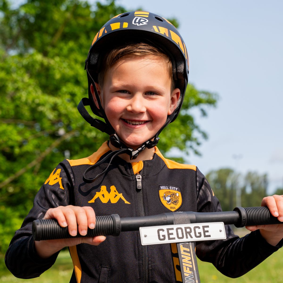 Child holding a personalised mini reg plate for a LIFERYDER scooter