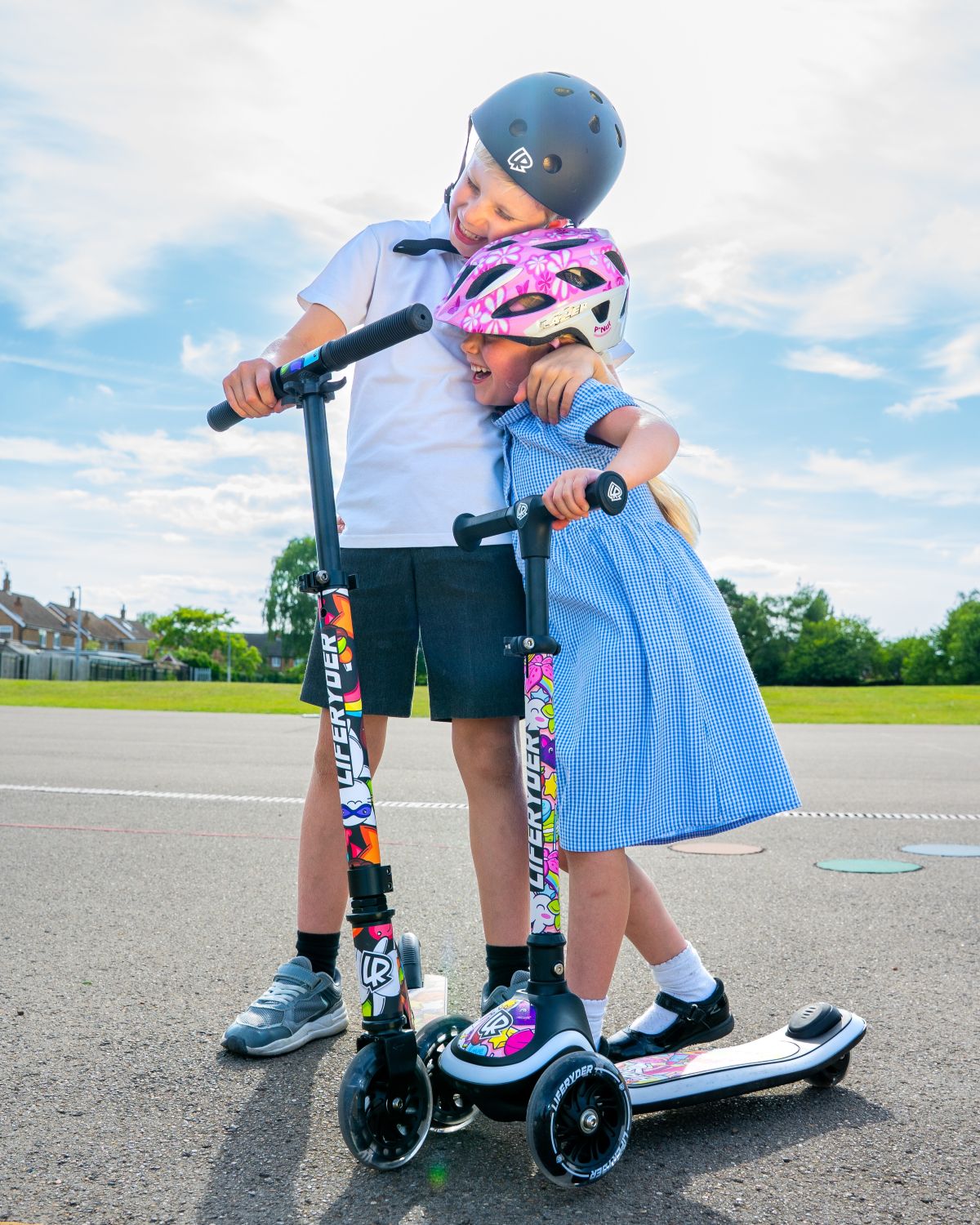 Children with LIFERYDER HALO and QUEST scooters on a paved path